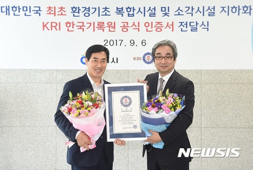  【하남=뉴시스】문영일 기자 = 한국기록원은 경기 하남시 환경기초시설이 폐기물 하수처리 등 11종에 이르는 복합시설과 소각 시설을 지하에 설치한 것이 국내 최초이자 최대 규모를 인정해 6일 오수봉 하남시장(왼쪽)이 공식 인증서를 전달했다. 2017.09.06. (사진=하남시청 제공) photo@newsis.com