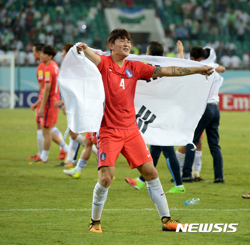 【타슈켄트(우즈베키스탄)=뉴시스】박주성 기자 = 5일(현지시간) 오후 우즈베키스탄 타슈켄트 분요드코르 경기장에서 열린 '2018 러시아 월드컵 아시아 최종예선' 대한민국 대 우즈베키스탄의 경기, 무승부를 거둔 대한민국 축구대표팀 김민재가 월드컵 본선 9회 연속 진출을 확정시킨 후 태극기를 몸에 걸치고 기뻐하고 있다. 2017.09.06. park7691@newsis.com