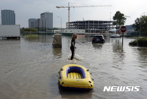 【휴스턴 ( 미 텍사스주 ) = AP/뉴시스】 = 일주일 째 물에 잠긴 휴스턴 침수지역의 아파트 단지에서 지역 자원봉사를 위해 나선 크리스티안 카(17)가 고무보트를 끌고 구조할 주민들을 찾아 나서고 있다.&nbsp; 