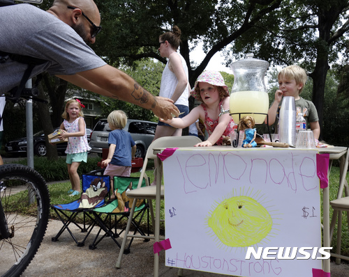 【휴스턴( 미텍사스주) = AP/뉴시스】 = 휴스턴 시내의 홍수피해가 없는 고지대 주민들중 5세의 캐서린 그레이스 에이번트가 길가는 사람들에게 고호기금을 위한 레모네이드를 팔고 있다.&nbsp; 