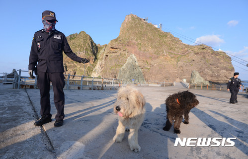 【독도=뉴시스】김선웅 기자 = 7일 오후 경북 울릉군 독도 동도에서 독도경비대원이 경비대에서 기르는 삽살개 흑미, 백미와 순찰을 돌고 있다. 2017.09.07. mangusta@newsis.com