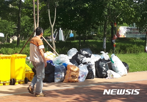 【대구=뉴시스】이통원 기자 = 대구 동구가 지난 5년 동안 지속적으로 쓰레기 무단투기 단속을 실시한 결과 적발건수는 늘고 있지만 여전히 쓰레기 무단투기는 끊이지 않고 있다. 사진은 대구 동구 이시아폴리스 내에 버려진 쓰레기 더미 옆으로 한 시민이 지나고 있는 모습이다. 2017.09.08.tong@newsis.com