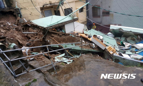 【부산=뉴시스】 하경민 기자 = 집중호우가 내린 11일 오전 10시 21분께 부산 중구 동광동의 한 2층짜리 주택이 붕괴됐다. 주택 거주자는 모두 대피했고, 119구조대가 옆 주택에 거주하는 노인을 대피시켰다. 2017.09.11. (사진=부산소방안전본부 제공) yulnetphoto@newsis.com