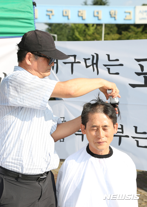 【경산=뉴시스】우종록 기자 = 12일 오후 경북 경산시 대구미래대학 정문에서 교수 등 20여명이 참석한 가운데 학생들의 학습권 보장과 교직원들의 생존권 마련을 요구하며 삭발식을 하고 있다. 2017.09.12. wjr@newsis.com