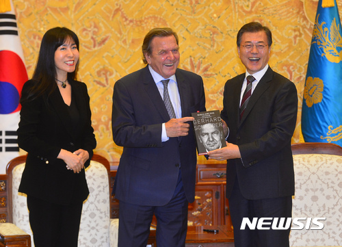 【서울=뉴시스】전진환 기자 = 문재인 대통령이 12일 오후 청와대 접견실에서 게르하르트 슈레더 전 독일 총리로부터 한글번역판 자서전을 선물받고 있다. 왼쪽은 번역한 김소연씨. 2017.09.12. amin2@newsis.com