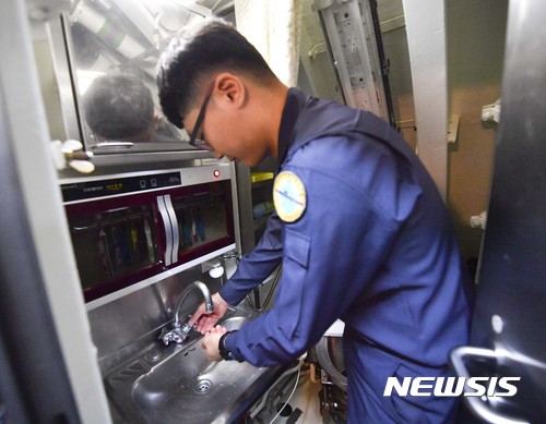 【제주=뉴시스】정윤아 기자 =한 승조원이 화장실 세면대에서 손을 씻고 있다. 잠수함은 화장실에 변기와 세면대, 샤워기가 같이 있다. 승조원은 40여명인데 비해 화장실은 단 2개뿐인 관계로 승조원 20명당 1개의 화장실·세면장을 이용함으로써 적시적인 생리욕구 해결 및 샤워 등이 자유롭지 못한 것이 현실이다. 단 2개뿐인 화장실로 인해 승조원 다수가 활동하는 주간 중에는 5분 이내로 모든 용무를 마치는 것이 불문율이다.(사진제공=해군)yoona@newsis.com