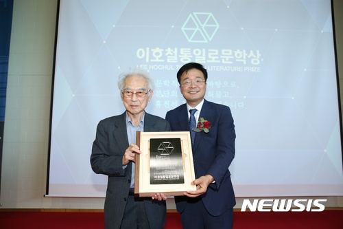 【서울=뉴시스】 서울 은평구가 17일 오후 경기 파주시 캠프 그리브스 유스호스텔에서 개최한 제1회 이호철 통일로 문학상 시상식에서 김석범(왼쪽) 작가가 김우영 은평구청장으로부터 상패를 수여받고 있다. (사진 = 은평구 제공) photo@newsis.com