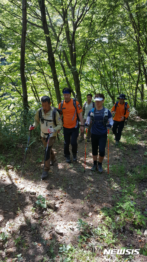 【산청=뉴시스】정경규 기자 = 지리산 산악마라톤에 참여했다가 실종된 A씨가 구조대에 의해 발견돼 함께 하산하고 있다.2017.09.18.(사진=산청소방서 산악구조대 제공)photo@newsis.com