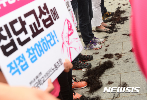 【서울=뉴시스】김진아 기자 = 19일 오전 서울 종로구 정부서울청사 앞에서 열린 전국학교비정규직노동조합원들의 근속수당 인상 및 교육부장관·교육감 직접 교섭 촉구 집단삭발 기자회견에서 조합원들이 삭발식을 하자 바닥에 머리카락이 흩어져 있다. 2017.09.19. bluesoda@newsis.com