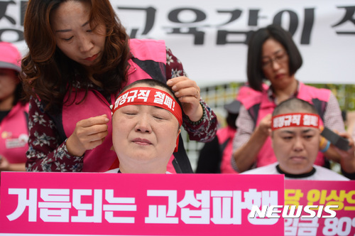 【서울=뉴시스】김진아 기자 = 19일 오전 서울 종로구 정부서울청사 앞에서 열린 전국학교비정규직노동조합원들의 근속수당 인상 및 교육부장관·교육감 직접 교섭 촉구 집단삭발 기자회견에서 조합원들이 비정규직 철폐가 적힌 머리띠를 하고 있다.2017.09.19. bluesoda@newsis.com