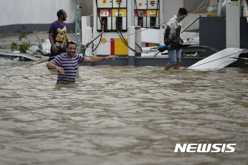 【우마카오=AP/뉴시스】푸에르토리코 주민들이 허리케인 마리아로 물에 잠긴 주유소 건물 옆을 지나가고 있다. 20일(현지시간) 80여년만에 가장 강력한 허리케인 마리아가 푸에르토리코 섬을 강타해 홍수가 발생하고 섬 전역에 전기가 끊겼다. 2017.09.