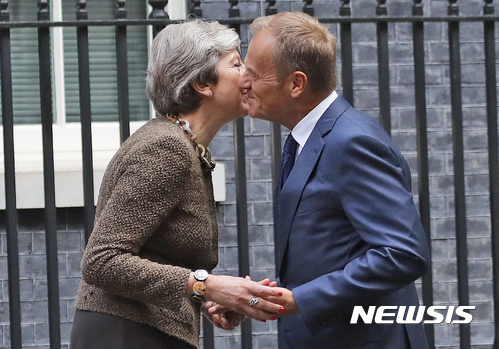 【런던=AP/뉴시스】테리사 메이 영국 총리가 26일(현지시간) 런던 다우닝가 10번지 총리 관저 앞에서 도날트 투스크 유럽이사회 의장 겸 정상회의 상임의장을 맞으며 볼을 맞대고 있다. 2017.09.27 