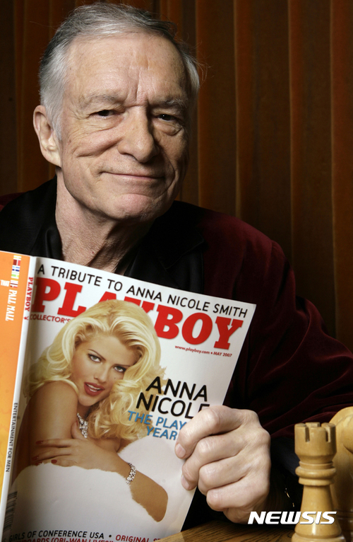 【로스앤젤레스=AP/뉴시스】남성 성인잡지 플레이보이를 창간한 휴 헤프너가 지난 2007년 4월5일 로스앤젤레스의 자택에서 자신의 플레이보이지를 들고 포즈를 취하고 있다. 헤프너는 27일 91세를 일기로 자택에서 노환으로 숨을 거뒀다. 2017.09.28
