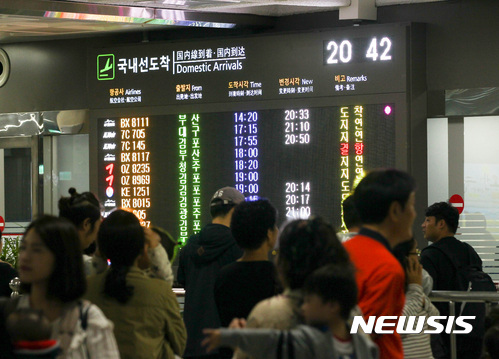【제주=뉴시스】우장호 기자 = 추석 연휴 이틀째인 1일 오후 난기류와 강풍에 항공기 운항 지연이 속출한 가운데 제주국제공항 1층 대합실에 귀경객들이 항공기 출도착 안내 화면에서 눈을 떼지 못하고 있다. 2017.10.01.&nbsp; woo1223@newsis.com