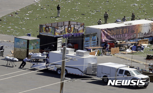 【라스베이거스 ( 미 네바다주) = AP/뉴시스】 = 라스베이거스 스트립에서 2일 발생한 무차별 총격사건의 희생자 시신들을 수사관들이 대형 운구트럭에 싣고 있다.