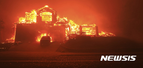 【산타로사(미 캘리포니아주) = AP/뉴시스】 = 캘리포니아 산불이 강풍을 타고 계속 번지면서 산타로사 일대의 한 주택이 불길에 휩싸여 있다.&nbsp; 이미 1500채의 주택과 상가가 불탔고 북부 포도주 생산지 일대가 심한 피해를 입었다.&nbsp;&nbsp; 