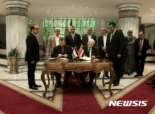 【카이로=AP/뉴시스】팔레스타인의 양대 정파인 파타와 하마스 측 대표가 12일(현지시간) 이집트 카이로에서 지난 10년간의 분열과 반목을 끝내는 합의서에 서명하고 있다. 2017.10.13 