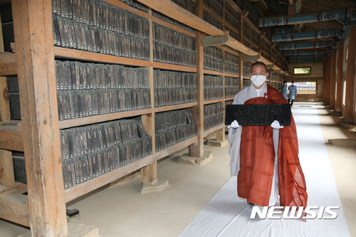 【합천=뉴시스】김기진 기자 = 경남 합천군과 해인사는 대장경 진본 8점의 이운(移運)을 알리는 고불식(告佛式)을 지난 16일 오후 해인사 장경판전 법보전 앞마당에서 진행했다고 17일 밝혔다. 사진은 16일 오후 대장경 진본 중 일부를 한 스님이 옮기고 있다. 2017.10.17. (사진=합천군 제공) photo@newsis.com