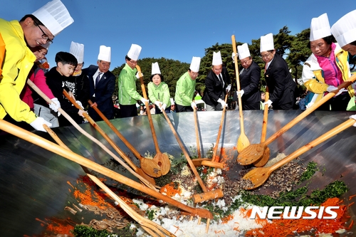 【보은=뉴시스】이성기 기자 = 지난 21일 충북 보은 속리산 잔디공원에서 보은지역 기관단체장 등이 속리산 천왕봉의 높이를 상징하는 1058명 분의 산채비빔밥을 비비고 있다. 이 비빔밥은 속리축전 행사에 참여한 관광객 등에게 무료로 제공됐다.2017.10.22(사진=보은군 제공) sklee@newsis.com  