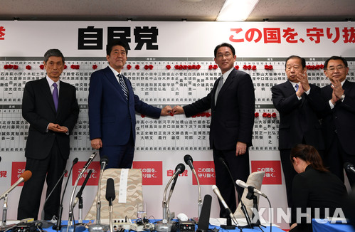 【도쿄=신화/뉴시스】아베 신조 일본 총리(왼쪽 두번째)가 22일 도쿄 자민당 당사에서 기시다 후미오 정조회장과 함께 중의원 선거 당선자 이름에 붉은 색 꽃을 붙이고 있다. 2017.10.23 
