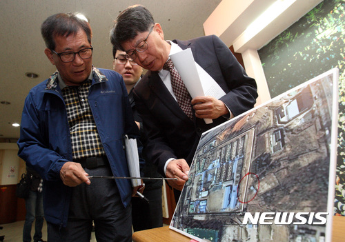 【광주=뉴시스】신대희 기자 = 5·18 기념재단이 23일 오전 광주 서구 치평동 기념재단 시민사랑방에서 '옛 광주교도소 5·18 암매장 발굴 관련 브리핑'을 열었다. 김양래 재단 상임이사(오른쪽)와 정수만 전 5·18 유족회장이 옛 교도소 전경을 보며 발굴 방법을 설명하고 있다. 2017.10.23.&nbsp; sdhdream@newsis.com 