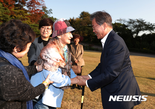 【서울=뉴시스】문재인 대통령이 23일 오후 청와대 녹지원을 관람중인 이효재 경신사회복지연구소 소장을 만나 손을 잡고 인사하고 있다. 2017.10.23. (사진=청와대 제공) photo@newsis.com