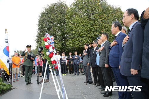 【서울=뉴시스】미국을 방문 중인 자유한국당 홍준표 (오른쪽 두 번째)대표가 23일 오후(현지 시각) 워싱턴 DC 한국전쟁 참전용사 기념비를 방문해 헌화하고 양국 국기에 대한 경례를 하고 있다. 2017.10.24. (사진= 자유한국당 제공) photo@newsis.com