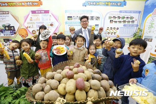 【서울=뉴시스】 24일 전라북도 전주시 농촌진흥청 농업과학관 2층 특별전시관에서 열린 '감자의 변신은 무죄! 감자의 무한매력' 전시회에서 이영희 국립식량과학원 원장과 청 어린이집 원생들이 전시된 감자를 보고 있다. 이번 전시회는 29일까지 열린다. 2017.10.24. (사진=농촌진흥청 제공) photo@newsis.com