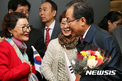 【서울=뉴시스】이영환 기자 = 자유한국당 홍준표 대표가 24일 오전(현지시간) 미국 워싱턴 덜레스국제공항에서 교민들과 인사를 나누고 있다. 2017.10.24. (사진=자유한국당 제공) photo@newsis.com