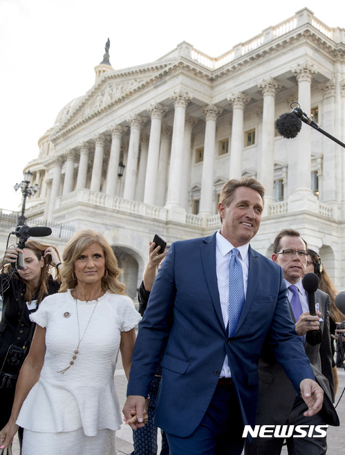 【워싱턴=AP/뉴시스】 제프 플레이크 미국 공화당 상원의원이 24일(현지시간) 워싱턴 의회에서 내년에 있을 중간선거 불출마 선언을 공식 발표한 뒤 부인 셰릴 여사의 손을 잡은채 걸어가고 있다. 그는 이날 도널드 트럼프 대통령을 신랄하게 비판했다. 2017.10.25