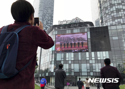 【베이징=AP/뉴시스】중국 베이징에서 25일 시민들이 대형 전광판을 통해 방송되는 시진핑 2기 지도부 발표 뉴스를 보고 있다. 2017.10.25 