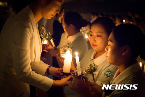 【대구=뉴시스】우종록 기자 = 25일 오후 대구 북구 복현동 영진전문대학 도서관 시청각실에서 열린 제31회 나이팅게일 선서식에서 영진전문대 간호학과 학생들이 촛불을 들고 간호정신 실천을 서약하고 있다. 2017.10.25. wjr@newsis.com