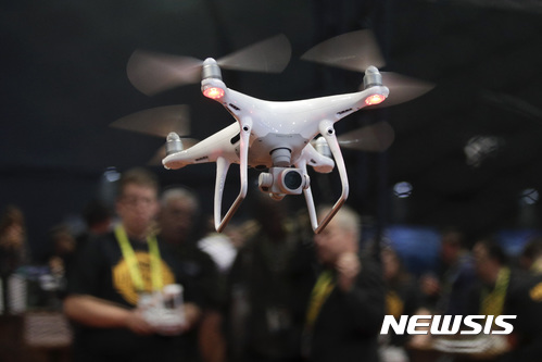 【라스베이거스(미 네바다주)=AP/뉴시스】지난 1월5일 미 네바다주 라스베이거스에서 열린 CES 인터내셔널에서 한 참가자가 드론 조종을 선보이고 있다. 도널드 트럼프 미 행정부는 25일(현지시간) 미 정부와 상업적 드론 사용 확대를 승인할 예정이다. 이에 따라 미국의 드론 사용이 늘어날 것으로 보인다. 2017.10.26