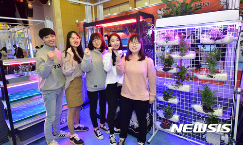 【대구=뉴시스】나호용 기자 = 27일 영진전문대 백호체육관에서 개최중인 종합작품전에서 식물재배시스템을 배경으로 이시현, 노현민, 손태주, 한혜원, 강경란(왼쪽부터)씨가 파이팅을 외치고 있다. 2017.10.27.(사진=영진전문대 제공) photo@newsis.com