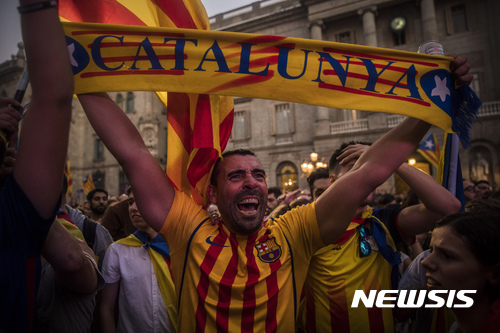 【바르셀로나(스페인)=AP/뉴시스】카탈루냐주의 분리독립을 지지하는 시위가 27일 바르셀로나에서 열린 가운데 한 남성이 카탈루냐라고 쓰인 스카프를 들어보이고 있다. 스페인 중앙정부는 28일 관보에 카탈루냐에 대한 직접 통치가 시작됐다고 고시해 직접 통치를 공식화했다. 2017.10.28