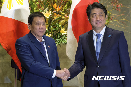 【도쿄=AP/뉴시스】로드리고 두테르테 필리핀 대통령이 2017년 10월 30일 일본 도쿄를 방문해 아베 신조 총리와 회담을 갖기 전 악수하고 있다. 2017.10.30 