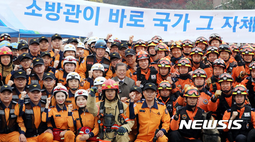 【천안=뉴시스】문재인 대통령이 지난 2017년 11월 3일 오전 충남 천안시 중앙소방학교에서 열린 '제55주년 소방의 날 기념식'에 참석해 소방시범훈련을 보인 시범단을 격려 후 기념촬영을 하고 있다. (사진= 뉴시스 DB)