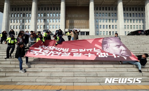 【서울=뉴시스】조성봉 기자 = 트럼프 미국 대통령 방한을 나흘 앞둔 3일 오후 서울 영등포구 여의도 국회 본청 계단에서 트럼프 방한을 반대하는 대학생들 30여명이 '전쟁막말 트럼프는 국회연설 할수 없다' 고 적힌  대형 플래카드를 들고 기습시위를 하고 있다. 2017.11.03.suncho21@newsis.com