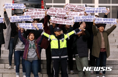 【서울=뉴시스】조성봉 기자 = 트럼프 미국 대통령 방한을 나흘 앞둔 3일 오후 서울 영등포구 여의도 국회 본청 계단에서 트럼프 방한을 반대하는 대학생들 30여명이 '전쟁위기 고조 무기강매 통상압력 트럼프를 반대한다' 라고 적힌 펼침막을 들고 기습시위를 벌이자 경찰이 두팔을 벌려 제지하고 있다. 2017.11.03.suncho21@newsis.com