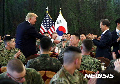 【서울=뉴시스】전신 기자 = 지난해 11월 경기도 평택시 캠프 험프리스에서 미국 트럼프 대통령이 장병들과의 오찬에 앞서 인사말을 마치고 문재인 대통령에게 마이크를 건네고 있다. 2017.11.07. photo1006@newsis.com