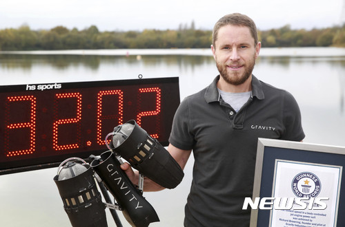 【런던=AP/뉴시스】‘현실판 아이언맨’이라 불리는 영국 발명가 리처드 브라우닝이 지난 9일(현지시간) 잉글랜드 레딩에서 자신의 제트 슈트를 착용하고 시속 51㎞로 날아 세계 신기록을 세운 뒤 기네스 신기록 인증서를 들고 있다. 2017.11.11 