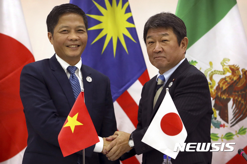 【다낭(베트남)=AP/뉴시스】미국을 뺀 11개 환태평양경제동반자협정(TPP) 가입국이 지난 11일 베트남 다낭에서 일본의 주도로 '포괄적, 점진적 TPP'(CPTPP) 이른바 TPP11를 구성하기로 합의했다. 합의를 한 이후 베트남의 쩐 뚜언 아인 산업무역부 장관(왼쪽)과 모테기 도시미쓰(茂木敏充) 일본 경제재생담당상이 악수하는모습. 2017.11.13