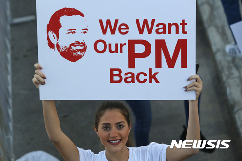  【베이루트=AP/뉴시스】 에마뉘엘 마크롱 프랑스 대통령이 15일(현지시간) 사우디아라비아 방문 중 퇴임을 전력 발표한 사드 알 하리리 레바논 총리와 그 가족을 프랑스에 초청했다 레바논 여성이 지난 12일 베이루트에서 하리리 레바논 총리의 귀환을 지지하는 플래카드를 들고 있다. 2017.11.16 