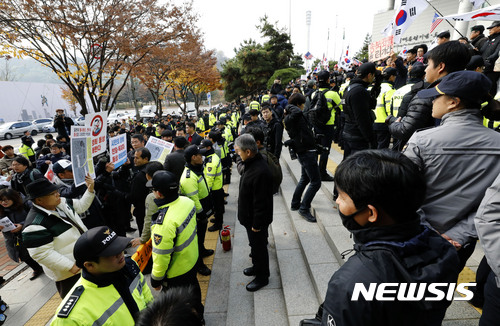 【서울=뉴시스】최동준 기자 = 박정희대통령 동상 기증식이 열린 13일 서울 마포구 박정희대통령기념도서관 앞에서 동상 건립에 찬성하는 단체와 반대하는 단체가 경찰 병력을 사이에 두고 구호를 외치고 있다. 2017.11.13. photocdj@newsis.com