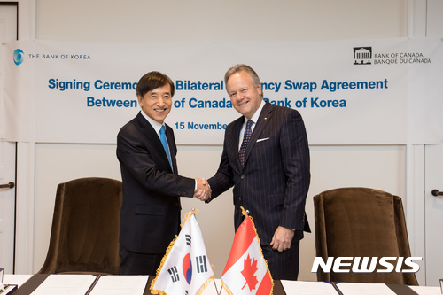 【서울=뉴시스】15일 오후(현지 시간) 캐나다 오타와에 위치한 캐나다중앙은행 본부에서 이주열(왼쪽) 한국은행 총재가 스티븐 폴로즈 캐나다중앙은행 총재와 양국간 통화스와프 협약서에 서명한 뒤 악수하고 있다.(사진 제공=캐나다중앙은행). photo@newsis.com 