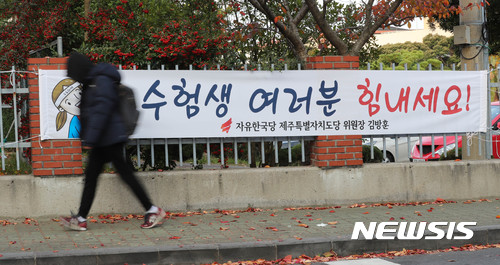 【제주=뉴시스】우장호 기자 = 경북 포항에서 발생한 지진으로 2018학년도 대학수학능력시험이 일주일 연기된 가운데 16일 오전 제주시 노형동 제주제일고등학교 울타리에 붙어 있는 수능 응원 현수막 앞으로 한 학생이 걸어가고 있다. 2017.11.16. woo1223@newsis.com