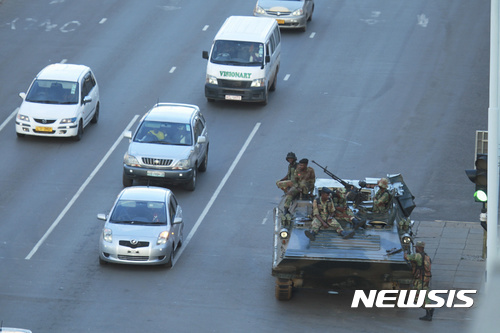 【하라레(짐바브웨)=AP/뉴시스】짐바브웨 수도 하라레의 로버트 무가베 대통령 집무실 앞 도로에 15일 무장 탱크 1대가 배치돼 있다. 짐바브웨군은 하라레와 국영방송을 통제하고 있으며 대통령 부부를 가택연금 중이라고 밝혔다. 사실상의 쿠데타로 무가베 대통령의 37년 장기 집권이 막을 내리게 된 가운데 지난주 해임된 에머슨 음난가그와 전 부통령이 권력을 장악할 것이 유력시되고 있다. 2017.11.16 