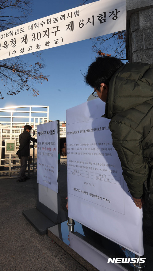 【수원=뉴시스】이정선 기자 = 지난 15일 경북 포항에서 발생한 규모 5.4 지진으로 2018학년도 대학수학능력시험이 일주일 연기된 가운데 16일 오전 경기 수원 수성고등학교에서 교직원들이 수능 연기 안내문을 붙이고 있다. 2017.11.16. ppljs@newsis.com