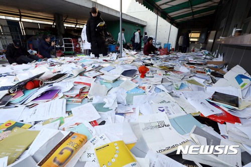 【서울=뉴시스】조성봉 기자 = 포항지진 여파로 2018학년도 대학수학능력시험이 연기된 16일 오전 서울 중구 종로학원 옥상에서 수험생들이 버렸던 참고서와 학습지를 다시 찾고 있다. 2017.11.16. suncho21@newsis.com