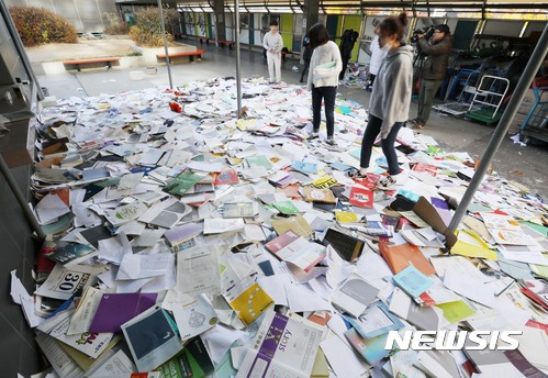 【서울=뉴시스】조성봉 기자 = 포항지진 여파로 2018학년도 대학수학능력시험이 연기된 16일 오전 서울 중구 종로학원 옥상에서 수험생들이 버렸던 참고서와 학습지를 다시 찾고 있다. 2017.11.16. suncho21@newsis.com
